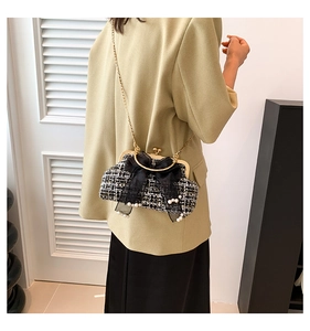 Detail van een tweed schoudertas met mesh strik en parels gedragen door een fotomodel