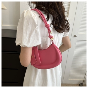 Close-up of pink crescent hobo bag with woven strap detail and gold hardware accents