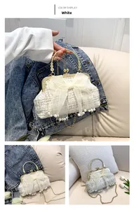 Detail of white tweed bag with organza bow, pearl fringe and golden chain strap