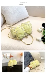 Detail of yellow tweed shell bag featuring a large mesh bow and pearl accents