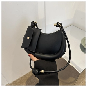 Detail of black crescent shoulder bag featuring a mini pouch and knot rope strap