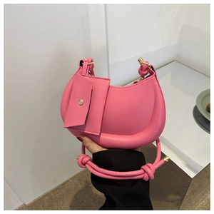 Pink crescent hobo bag with knotted handle and matching mini flap pouch detail
