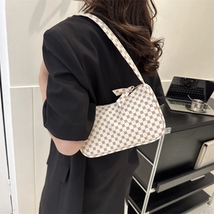 Minimalist cream shoulder bag with red geometric print and bow detail on a fashion model