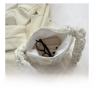 Detail view of pearl white puffy pleated bag interior showing large daily storage capacity