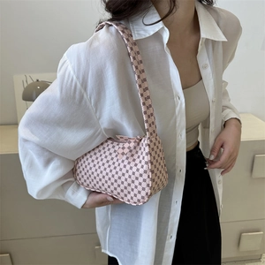 Pink baguette shoulder bag with geometric circle pattern worn by a model in a minimal setting