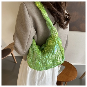 Close-up of bright green metallic quilted puffer bag with chic ruched strap detail