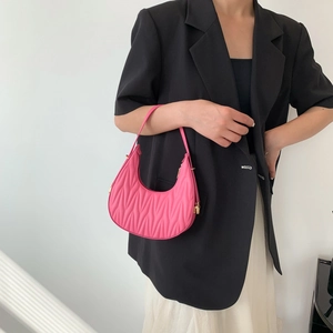 Chic pink matelassé crescent shoulder bag with golden hardware and a minimalist design