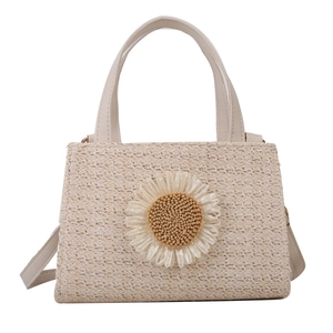 Beige woven crossbody bag with decorative daisy flower and adjustable shoulder strap