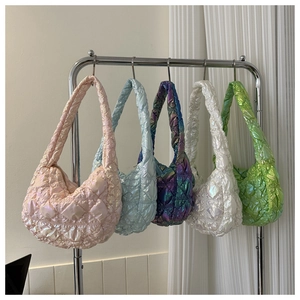 Detail view of colorful glossy quilted puff shoulder bags in light pink, blue and green