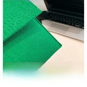 Gros plan détaillé d'une pochette verte à motif crocodile avec des coutures soignées