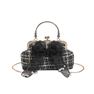 Elegant tweed handbag with black lace bow and pearl details on white background