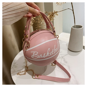 Dettaglio della borsa a tracolla creativa a forma di basket rosa con catena dorata