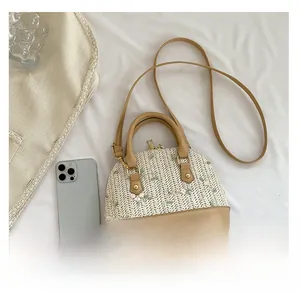 Flat lay of straw woven shell bag with floral lace embroidery and faux leather handles