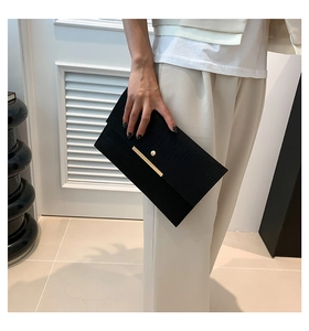 Gros plan sur pochette noire à relief crocodile avec détails en métal doré chic