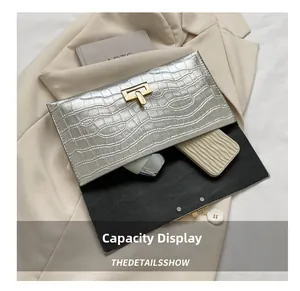 Capacity display of silver crocodile-patterned clutch with T-bar metal lock clasp