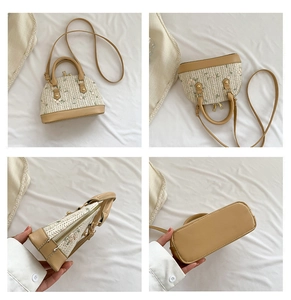 Detail of straw shell bag with floral embroidery and adjustable leather strap
