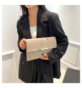 Détail de la pochette enveloppe en feutre gris avec rabat croco et barre en métal doré