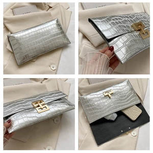 Macro detail of silver crocodile embossed handbag showing gold buckle and inner space