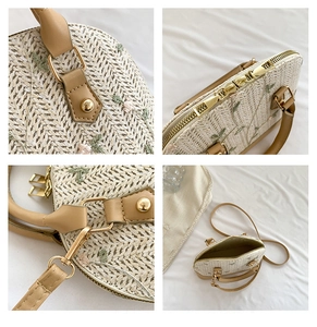 Detail view of straw woven bag showing embroidery, metal zippers, and leather straps