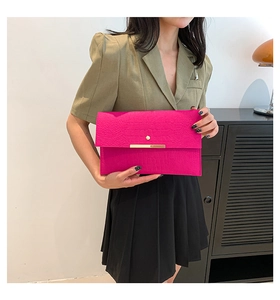 Détail de la pochette enveloppe fuchsia avec gaufrage crocodile et fermoir en métal doré