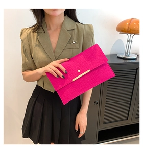 Détail de pochette en cuir PU fuchsia à motif crocodile et barre métallique dorée