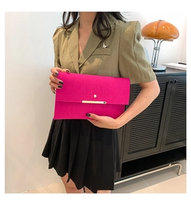 Détail de la pochette enveloppe fuchsia avec gaufrage crocodile et fermoir doré chic