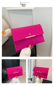 Vue détaillée d'une pochette enveloppe rouge rose avec texture croco et garniture dorée