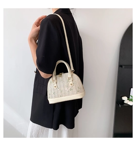Straw shell bag with pink flower embroidery and white leather trim on model