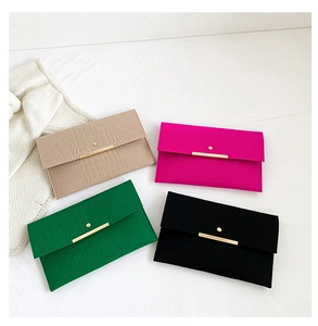 Détail de quatre pochettes enveloppe colorées avec garnitures dorées et texture croco