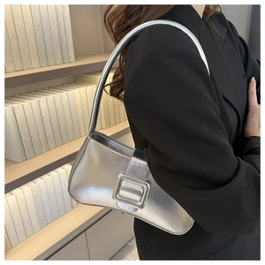 Silver metallic shoulder bag with large square buckle shown on model in modern setting