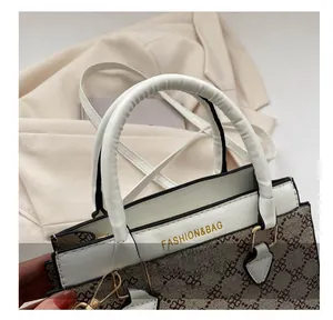 Detailed close-up of white leather handles and vintage floral pattern on a square bag