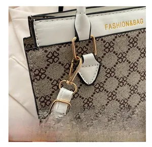 Detailed close-up of golden metal hooks and clover pattern on this stylish handbag