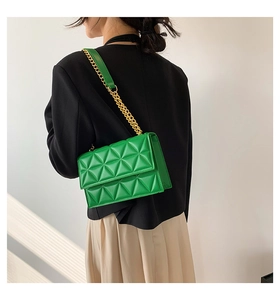 Detail der leuchtend grünen Stepptasche mit eleganter goldener Ketten-Schulterriemen