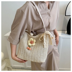 Détail du sac cabas en paille beige avec fleurs 3D jaunes et accents de nœuds en dentelle