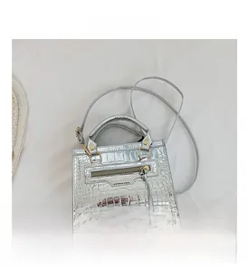 Detail view of silver crocodile pattern texture on a stylish metallic handbag