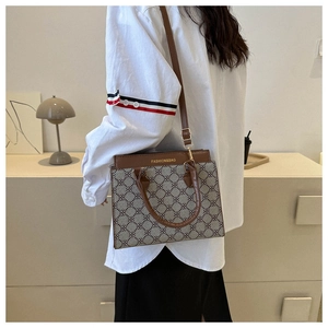 Detail view of the vintage crossbody handbag featuring geometric floral patterns and brown leather straps