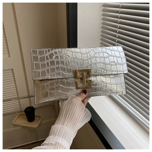 Close-up of silver crocodile pattern envelope clutch bag with gold interlocking buckle
