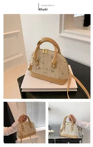 Detail of khaki leather handle and floral embroidery on white woven straw handbag