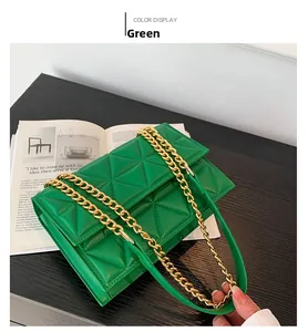 Detail der grünen gesteppten Umhängetasche mit goldener Kette auf einem Magazin