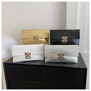 Close-up of stylish faux crocodile leather clutches in gold, black, white, and silver tones