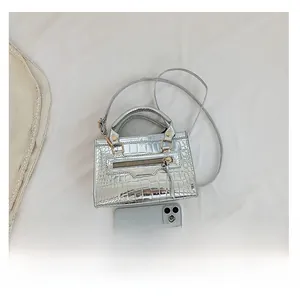 Silver crocodile textured handbag with adjustable shoulder strap and smartphone size reference