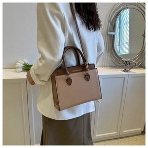 Detail of a brown and beige patchwork crossbody bag with Fashion & Bag lettering on top