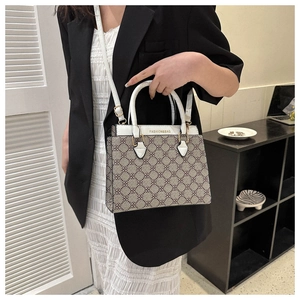 Close-up of brown monogram pattern and white leather shoulder bag shown on model