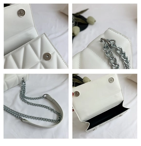 Detail view of white quilted crossbody bag with silver chain strap and magnetic snap closure
