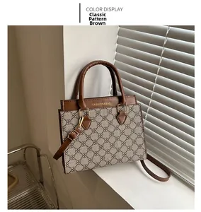Detail view of brown monogram handbag with gold Fashion and Bag logo and leather strap