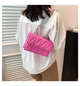 Detail of rose pink chain shoulder bag with geometric stitching and silver metal strap