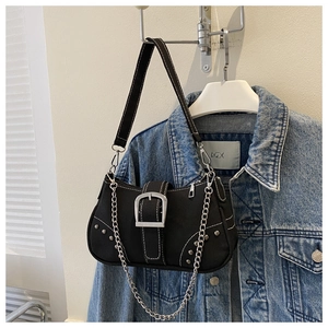 Detail of black canvas underarm bag with silver buckle, rivets, and metal chain strap