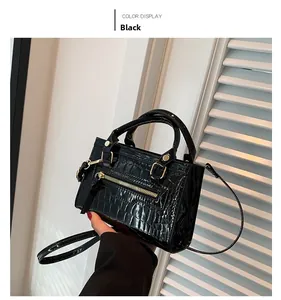 Detail of black faux leather handbag with glossy stone texture and metal zipper