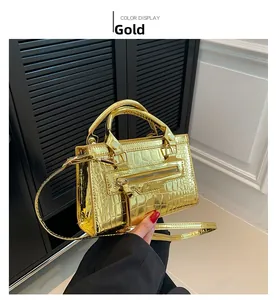 Detailed view of gold crocodile embossed finish on a mini square moto handbag