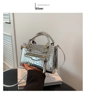 Detail of silver crocodile pattern handbag with metallic mirror finish and metal zipper